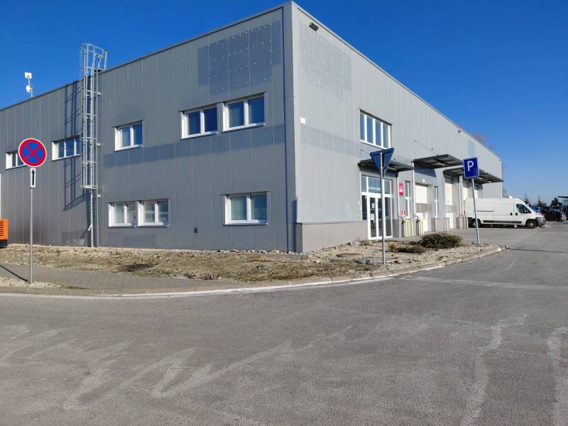 Raktárak és csarnokok a Pozsony-Ružinov Technikai utcában parkolóval és közlekedési táblákkal.