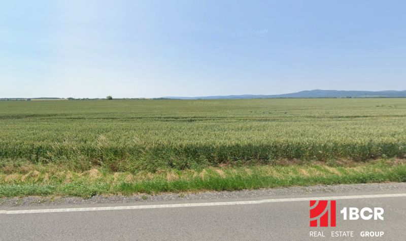 Mezőgazdasági és erdőterületek Budmericen kiterjedt mezőkkel és távoli dombokkal.
