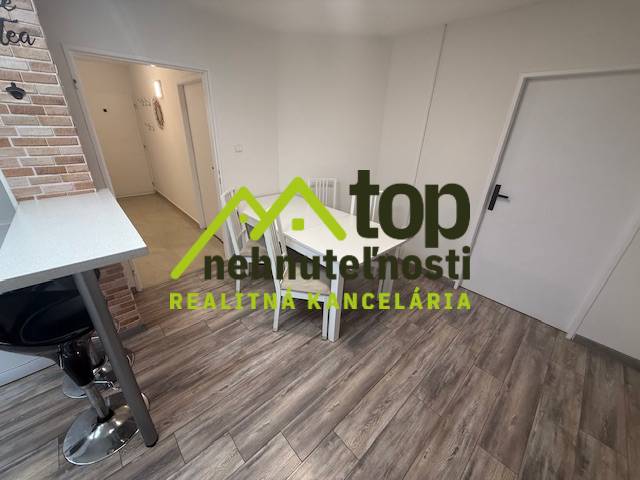 1 szobás lakás fa dekor padlóval és étkezőasztallal.