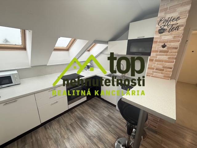 Konyhai tér egy egyszobás lakásban fa dekor padlóval és tetőablakokkal.