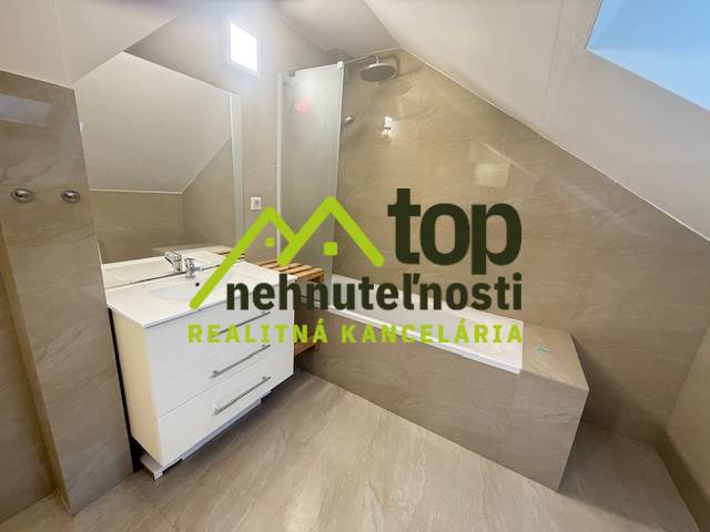 Fürdőszoba egy egyszobás lakásban zuhanyzóval és mosdóval.