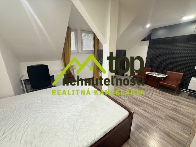 Hálószoba egy egyszobás lakásban fa dekor padlóval és íróasztallal.