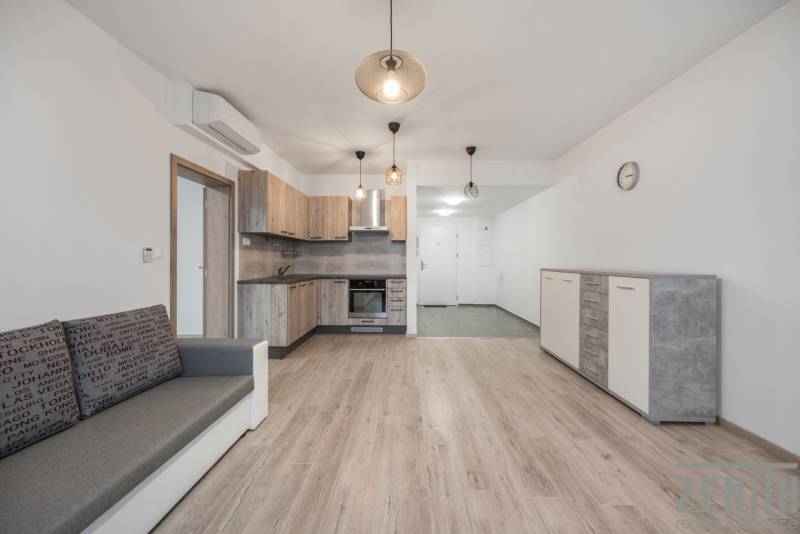 Nappali konyhával és fa dekorációjú padlóval egy kétszobás lakásban.