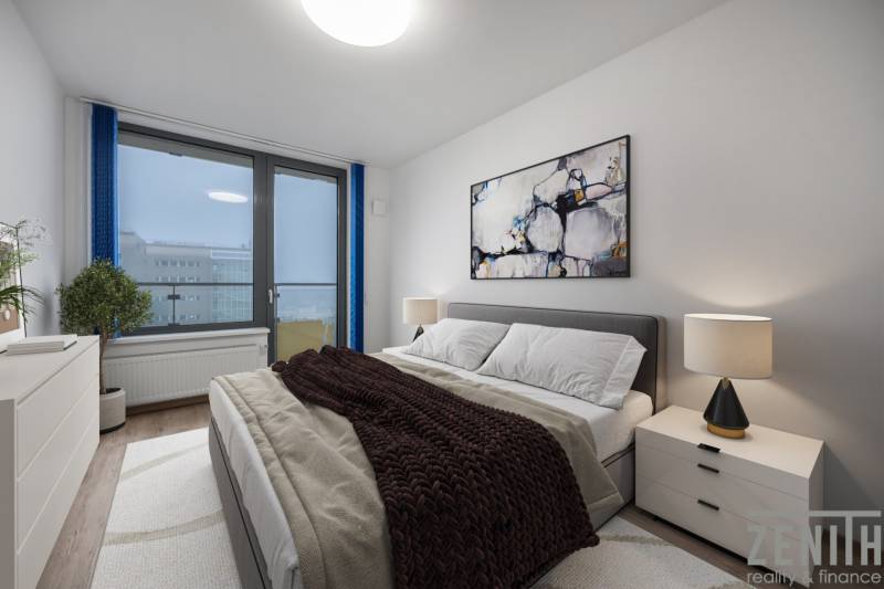 Hálószoba egy kétszobás lakásban kényelmes ággyal, képpel és lámpával az éjjeliszekrényen.