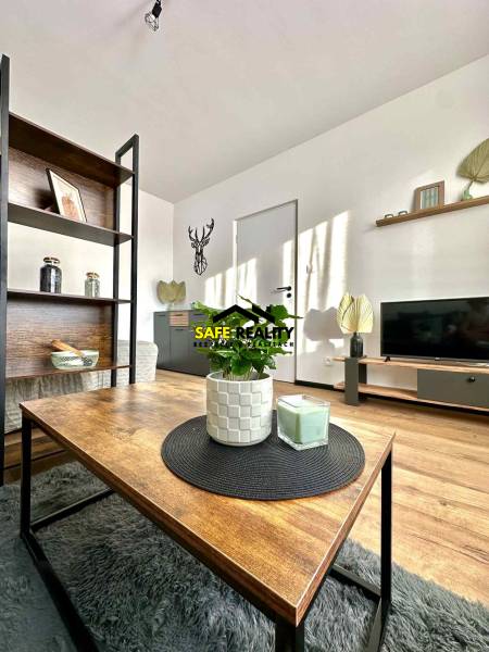 Nappali egy egyszobás lakásban, fa dekorációjú padlóval és dekorációkkal.