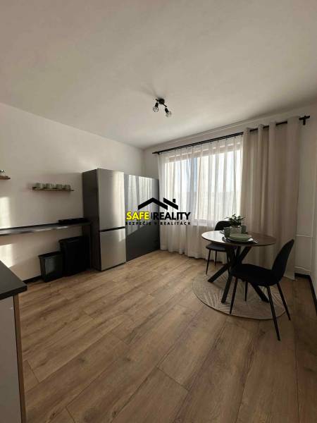 Konyha fa mintázatú padlóval és asztallal egy egyszobás lakásban.