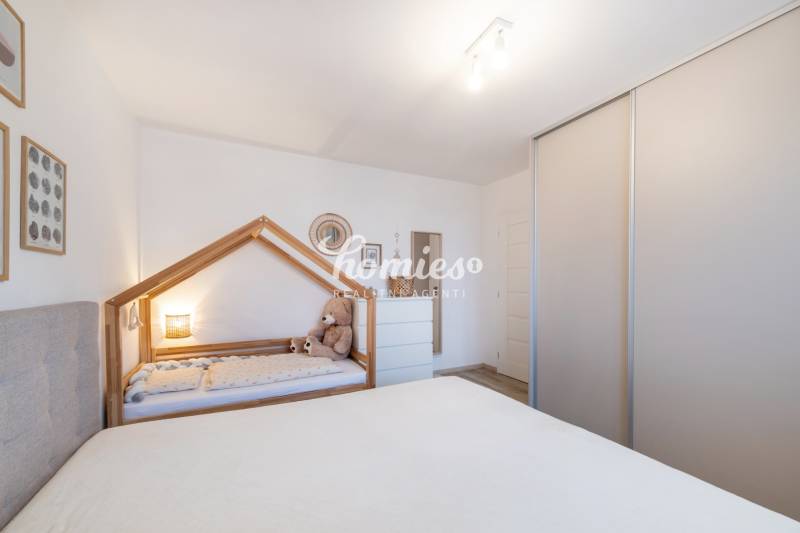 Gyerekszoba egy kétszobás lakásban, gyerekággyal és szekrénnyel.