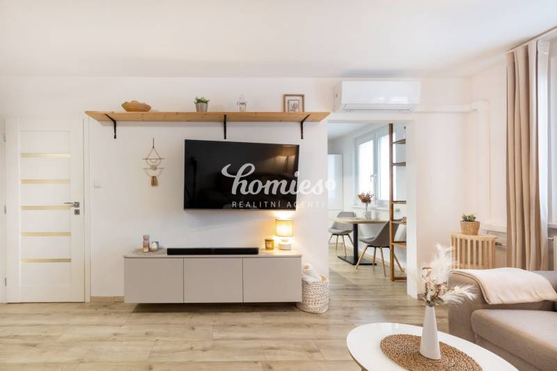 Nappali egy kétszobás lakásban televízióval, fa dekorációjú padlóval.