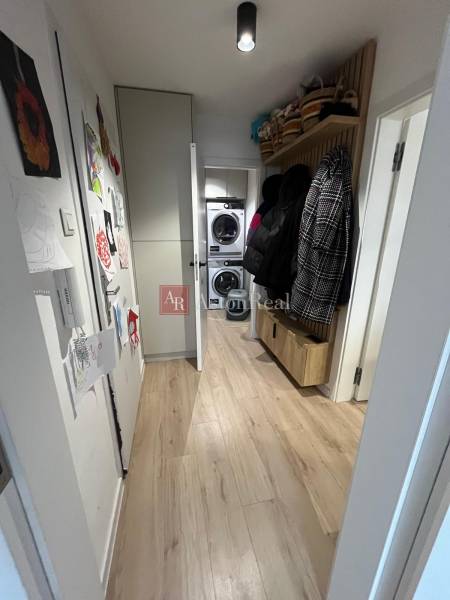 Keskeny folyosó szekrényekkel és fa dekorációjú padlóval egy négy szobás lakásban.