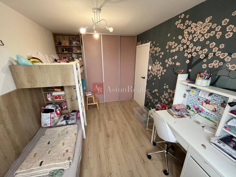 Gyerekszoba emeletes ággyal, íróasztallal és fa dekorációjú padlóval egy 4 szobás lakásban.