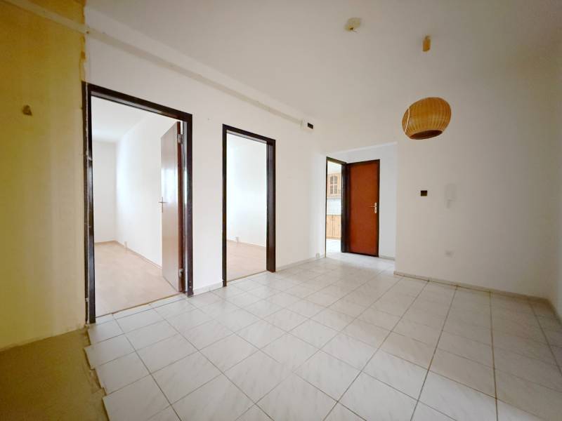 Egy 4 szobás lakás belső tere fehér falakkal, csempével és fa dekorációjú padlóval.