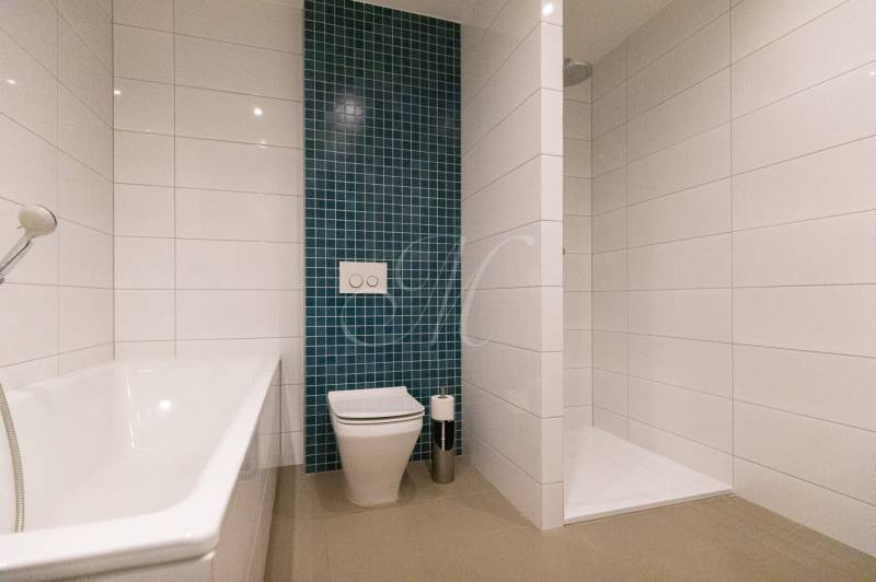 Fürdőszoba zuhanyzóval és káddal egy kétszobás lakásban.