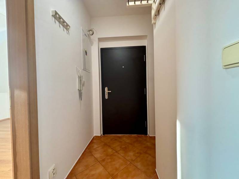 Előszoba sötét ajtókkal egy kétszobás lakásban, fehér falak és járólap.