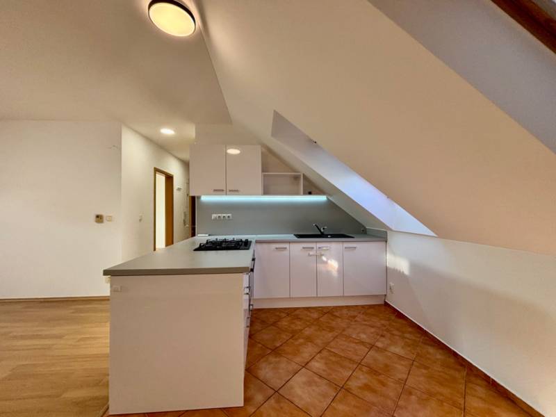 Konyha egy kétszobás lakásban konyhabútorral és kerámia padlóval.