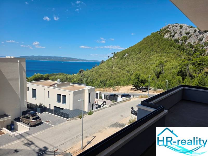 Kilátás egy makarskai üdülőapartmanból a tengerre és a zöld dombokra.