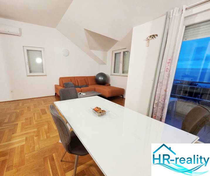 Étkező és nappali egy üdülő apartmanban fa dekorációjú padlóval.