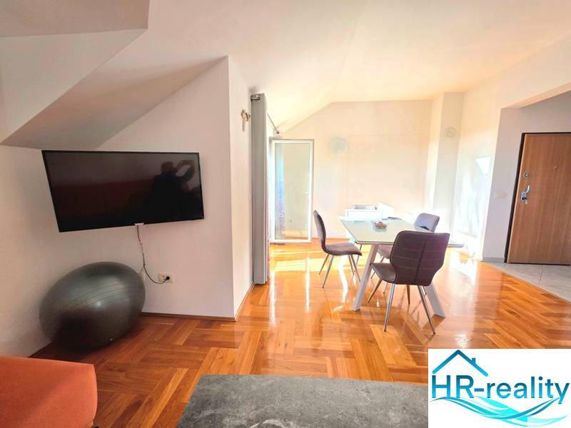 Egy nyaraló apartman belső tere fa dekor padlóval és étkezőasztallal.