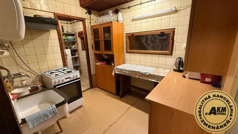 Konyha a faháznál gázkályhával, fa dekorációval és konyhapulttal.