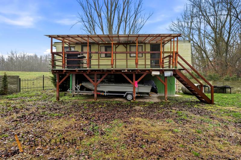 Ház Gabčíkovo-ban emelt teraszos emelvényen, hajóval a szerkezet alatt.