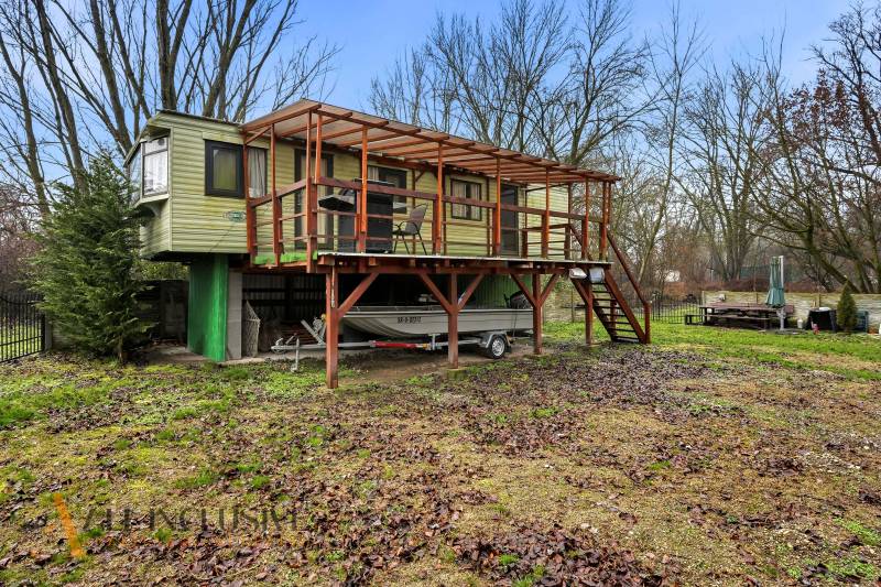 Ház Gabčíkovo-ban terasszal és lépcsőkkel, hajó a tető alatt, őszi táj.