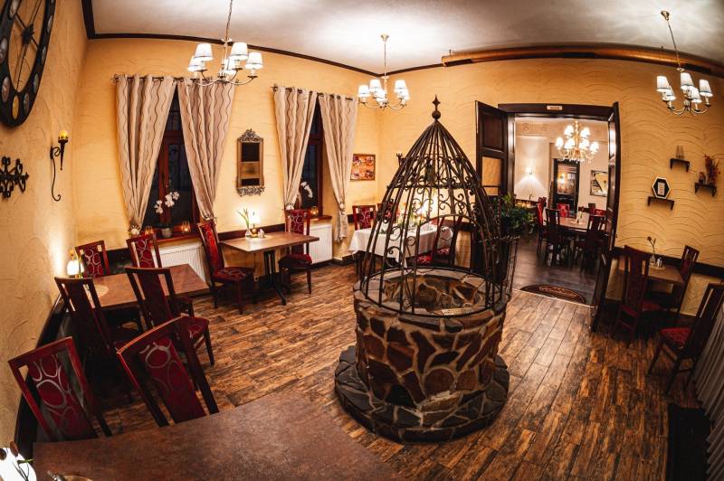 Szállodai és panzió étterem kandallóval és fa dekorációjú padlóval.