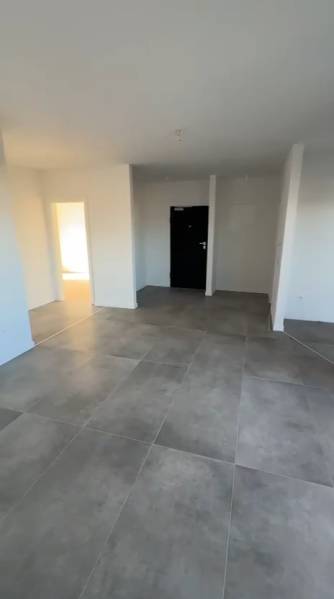 3 szobás lakás belső tere nagy csempékkel és fehér falakkal.