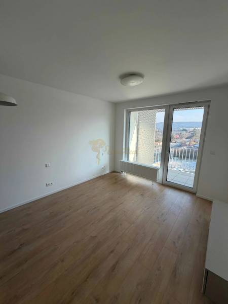 Garzonlakás fa dekorációjú padlóval és erkélyes kilátással a városra.