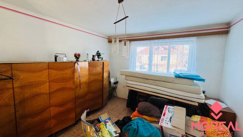 Szoba egy családi házban fa bútorokkal, csillárral és ablakkal, kilátással.