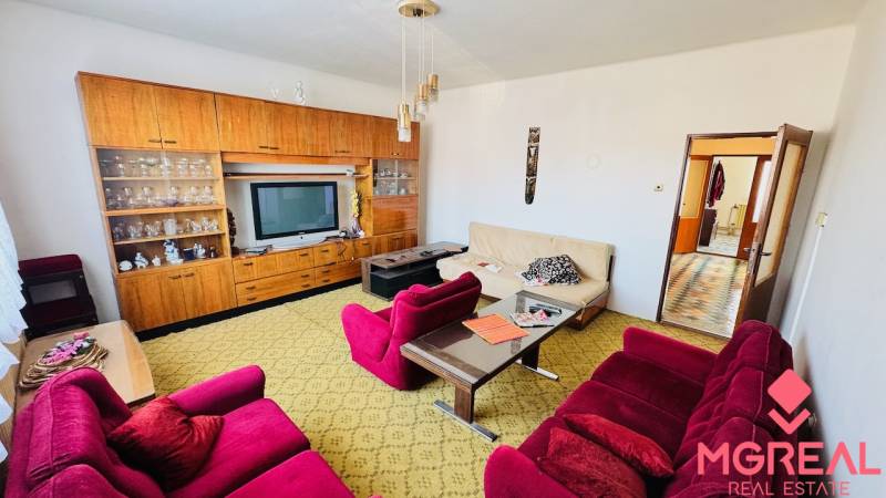 Nappali egy családi házban retro bútorokkal és színes fotelekkel.