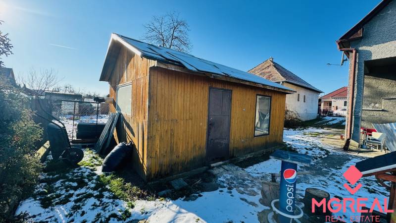 A partizánskei Nagybélben, egy ház mögött egy faház áll a havas udvaron.