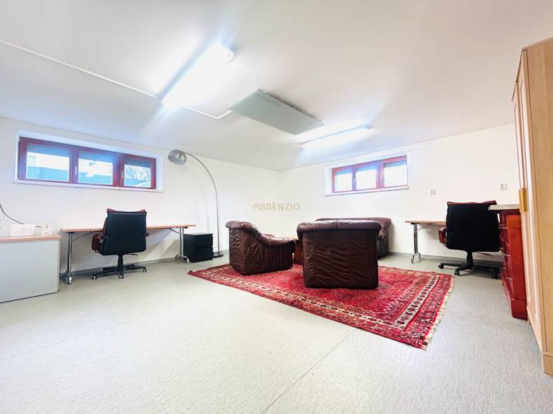 Otthoni iroda szőnyegdekorációval és bőrfotelekkel egy családi házban.