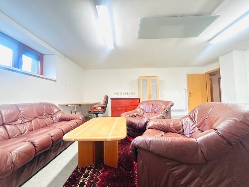 Bőr ülőgarnitúra dohányzóasztallal, szőnyeggel és dolgozósarokkal a családi házban.