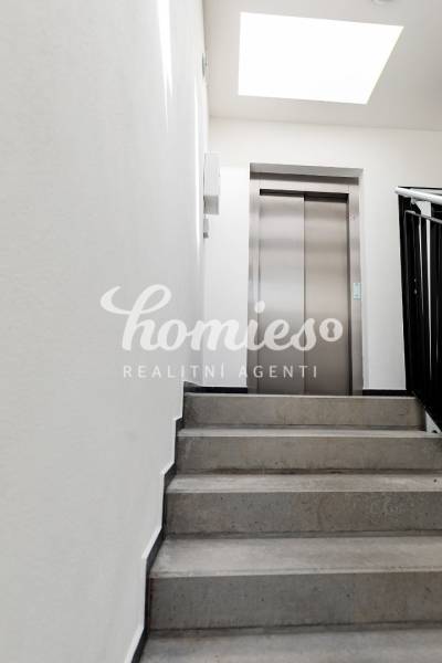 Lépcsőház a lifthez egy háromszobás lakásban, világos tér.