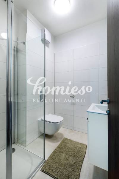 Fürdőszoba egy háromszobás lakásban WC-vel, zuhanyzóval és mosdóval.