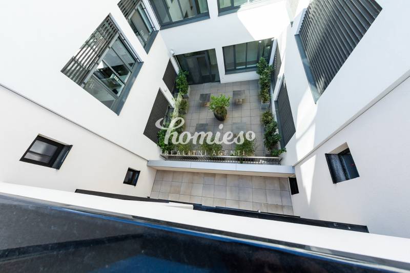 A nyitrai lakókomplexum belső udvara teraszburkolattal és zöldterülettel.