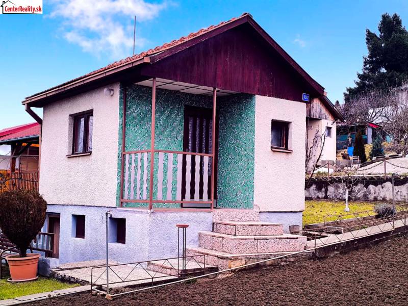 Ház Partizánske-ban parkosított kerttel, zöld homlokzattal és teraszra vezető lépcsővel.