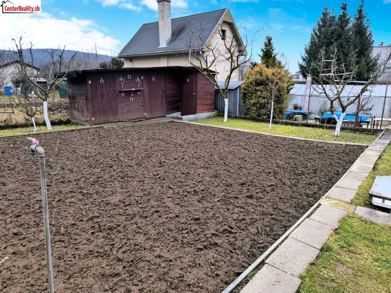 Kert házzal Partizánske városában, előkészített ágyás, környező zöldterület és faház.