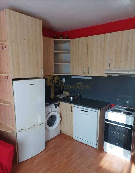 Konyhasarok fa dekorációval és készülékekkel egy egyszobás lakásban.