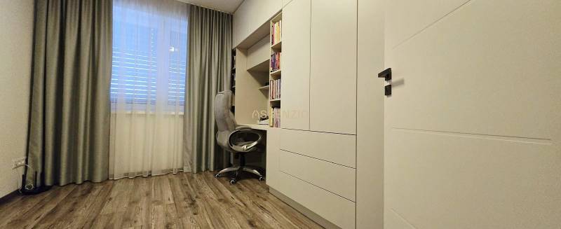 Tanulószoba családi házban, dolgozósarokkal, fehér bútorokkal és fa mintázatú padlóval.