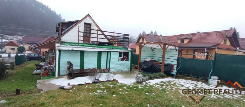 Cintorínska utcai családi ház Divínban, udvaron lévő tetővel és havas gyepfelülettel.