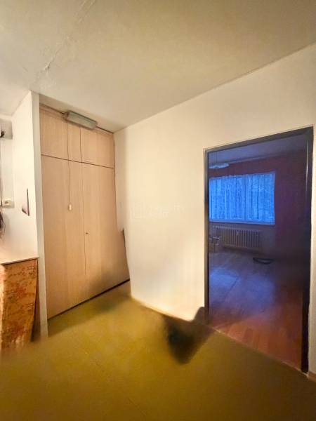 Folyosó beépített szekrénnyel egy 3 szobás lakásban, belépés a szobába fa dekoros padlóval.