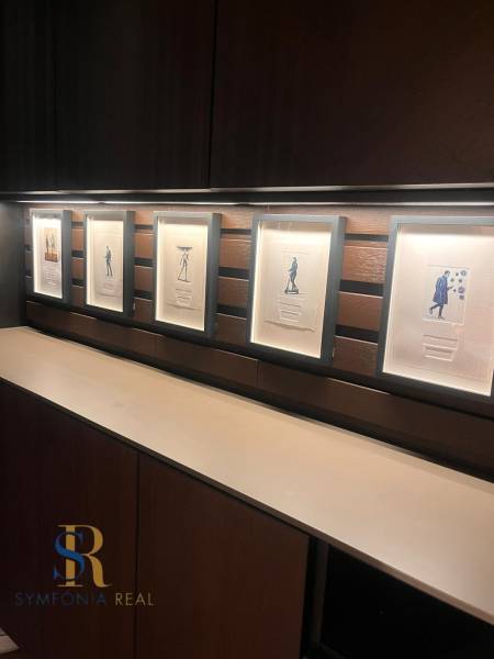 Keretbe foglalt képek egy kétszobás lakás fa polcos falán.