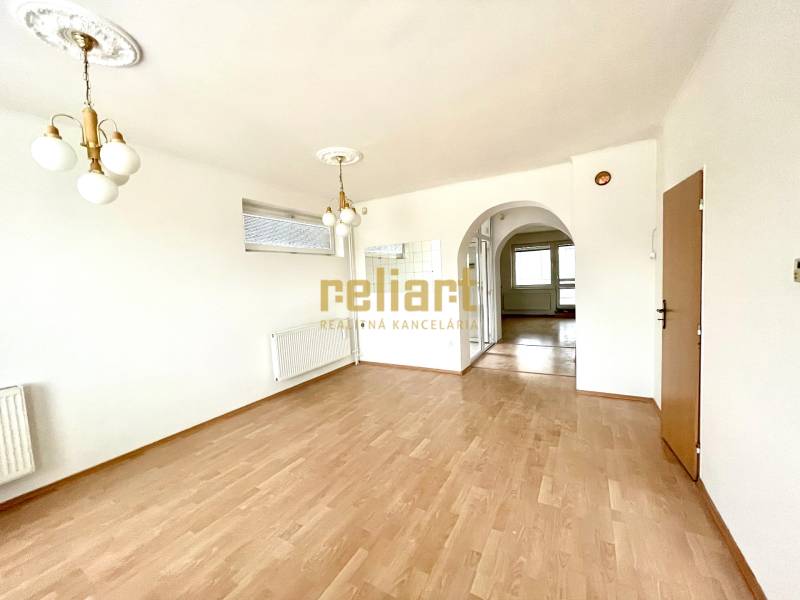 Családi ház belső tere fa dekorációjú padlóval és díszített világítással.