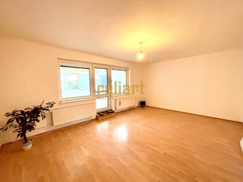 Szoba egy családi házban, fa dekoros padlóval és nagy ablakokkal.