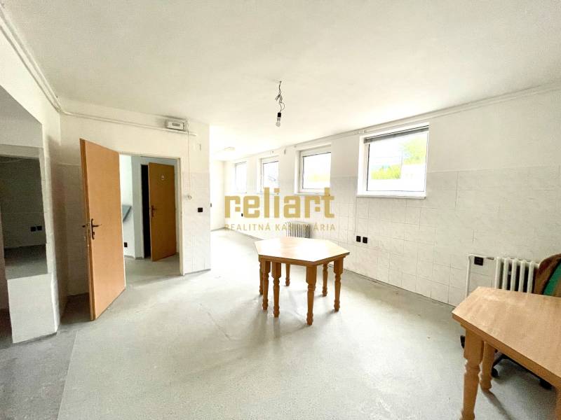 Családi ház belső tere üres szobával, asztalokkal és fehér falakkal.