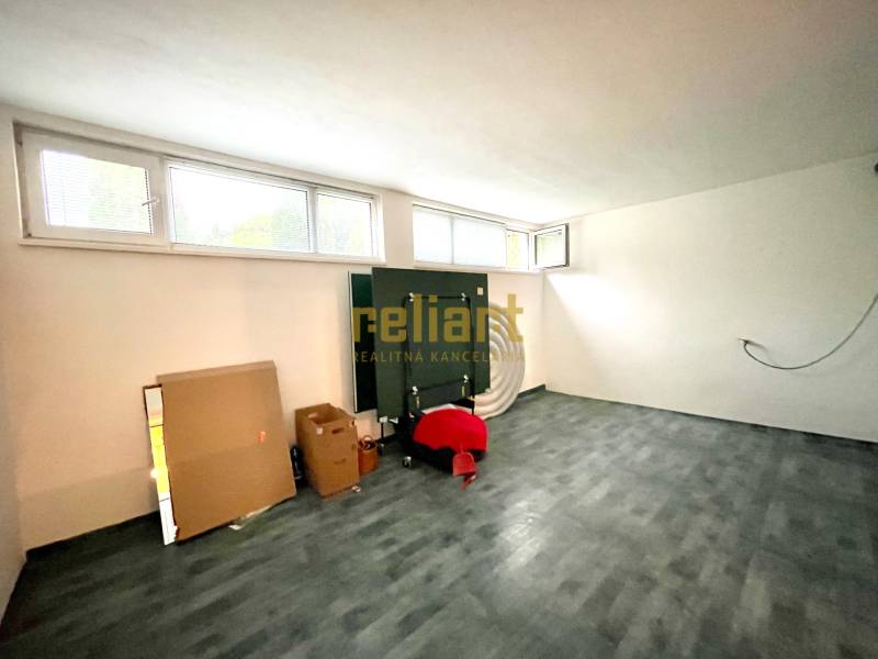 Szoba egy családi házban fa dekorációjú padlóval, ablakokkal és kartondobozokkal.