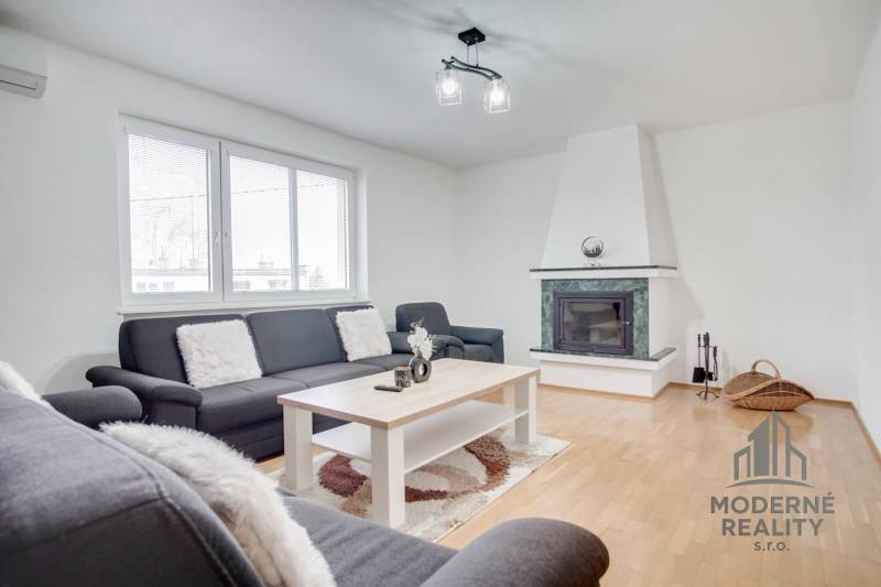 Nappali egy 4 szobás lakásban kandallóval és fa dekoros padlóval.