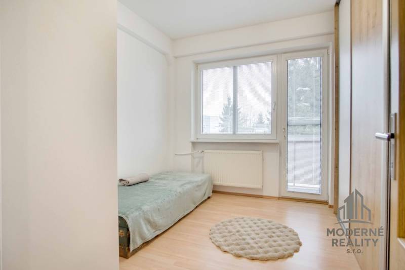 Egyszerű szoba fa dekor padlóval és kinyitható ággyal egy 4 szobás lakásban.