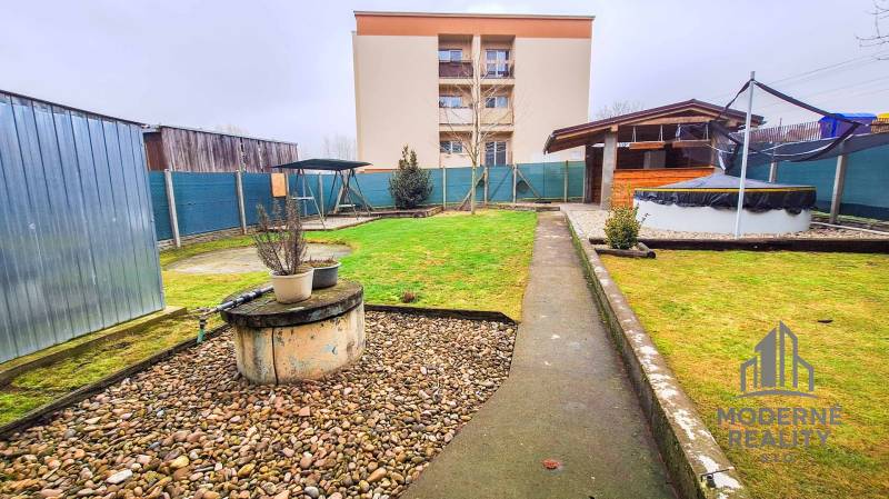 Kert a 4 szobás lakásnál Koltán, zölddel, fészerrel és fedett kerti ülőhellyel.