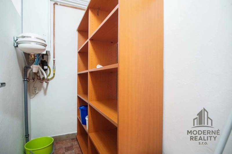 Tárolóhely polcokkal és mosdóval egy 4 szobás lakásban.